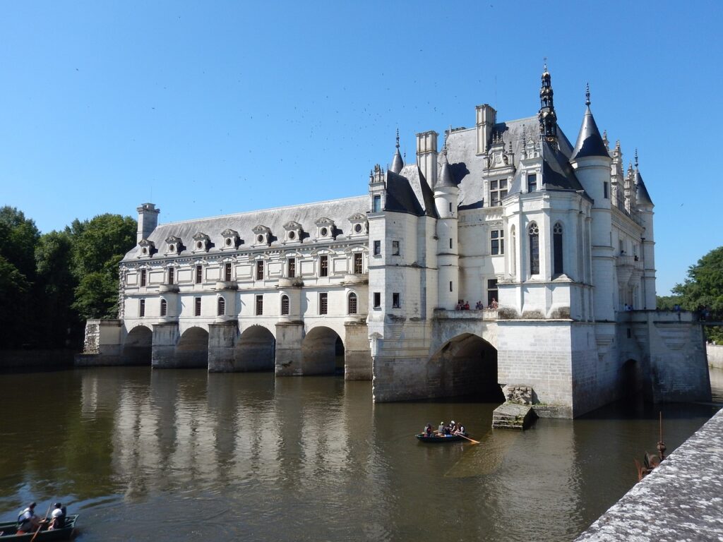 Vue du Château de Chenonceau s'étendant au-dessus de la rivière Cher avec ses arches élégantes et ses jardins.